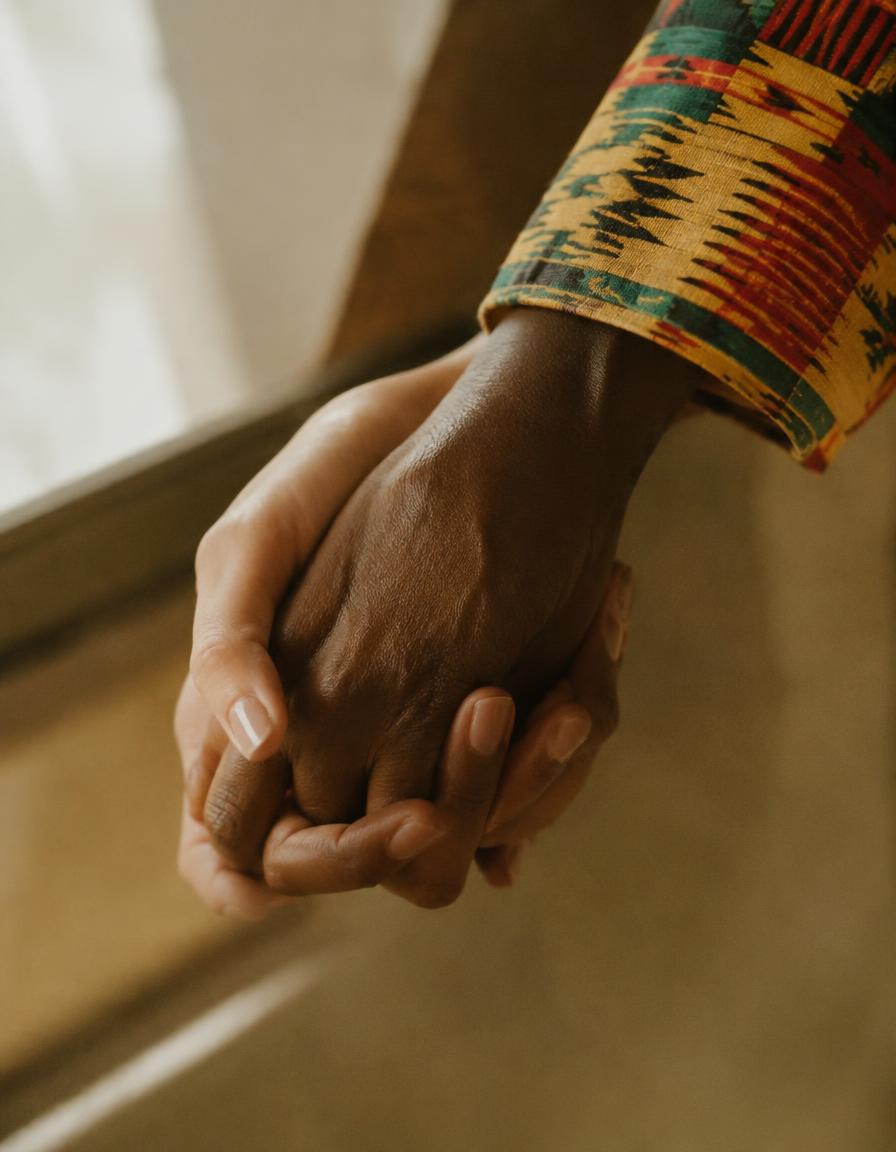 Sample image: two hands held together, one sleeve in kente cloth